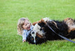 cute boy with curly blonde hair embraces a bernese mountain dog

